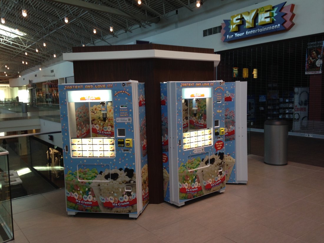Two Mini Melts vending machines near FYE at a mall